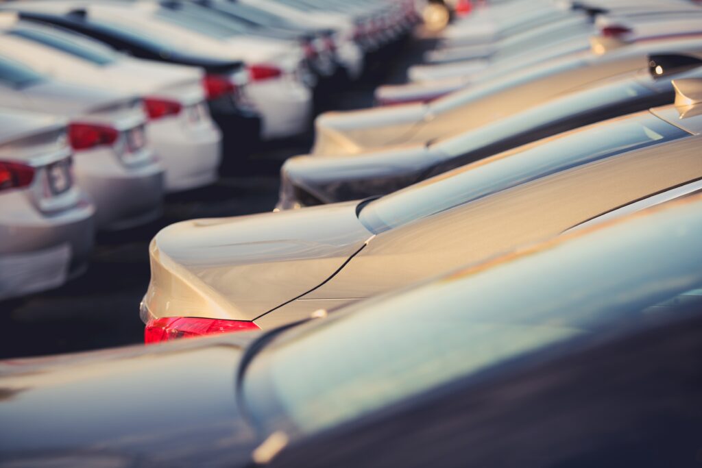 New Cars Dealer Stock Closeup Selective Focus. Parking Lot Full of New Vehicles.