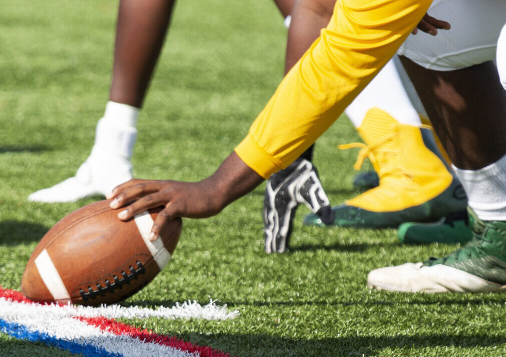 Football player holding football on field ready to start a play